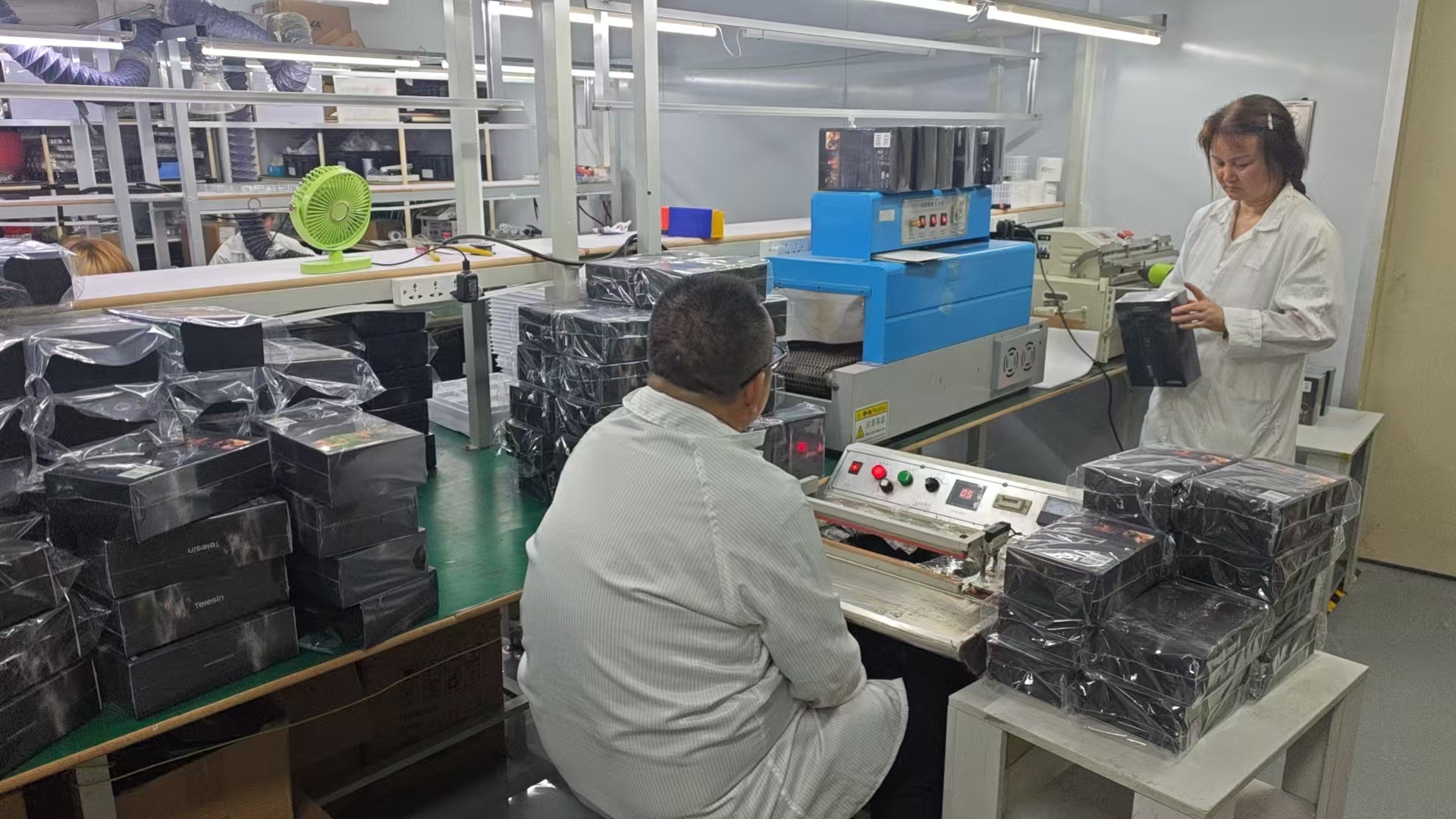 Kwin Electronics packing line with shrink-wrap sealing station