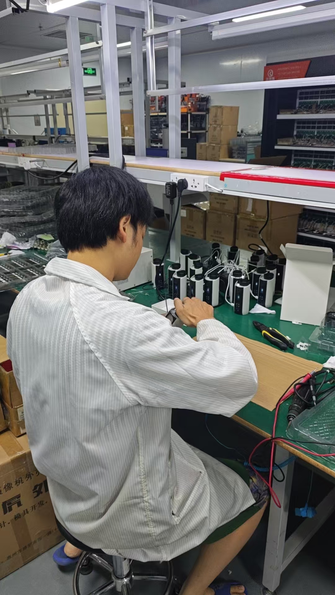 Kwin Electronics workshop worker assembling and testing portable devices